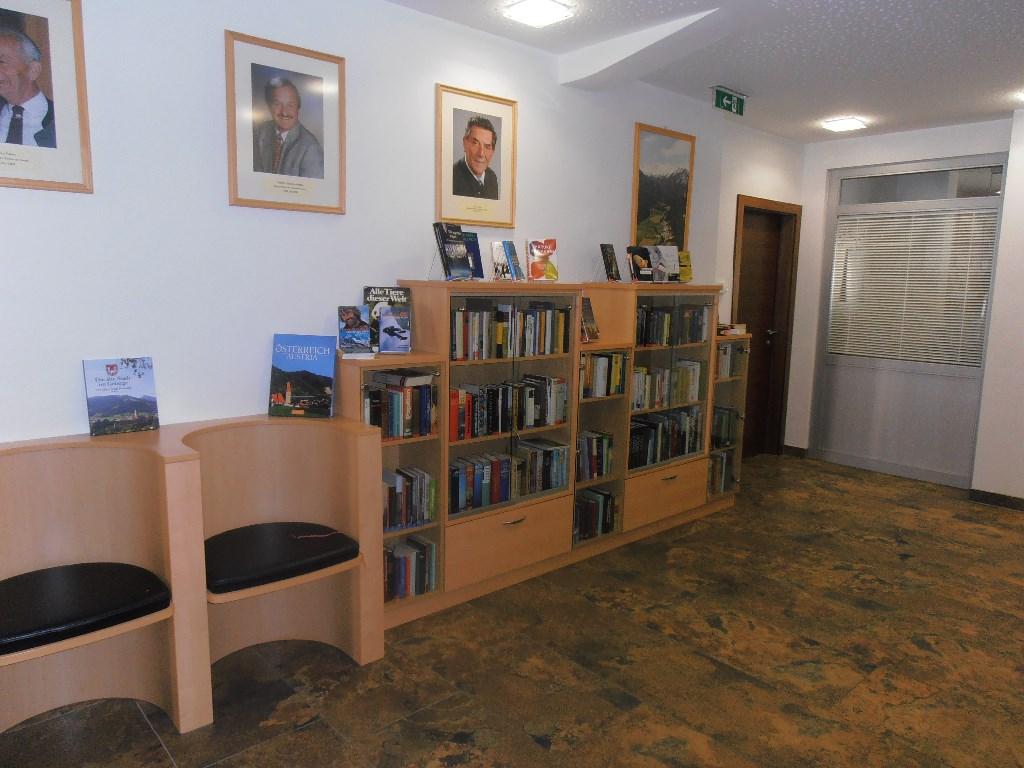 Bücherei innen - Regale und Sitzgelegenheit davor auf der linken Fotoseite